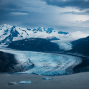 Photo of mountains and and frozen ice and snow coming down glaciers in Alaska