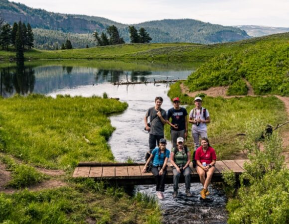 nat-geo-student-group-smiling-on-yellowstone-bridge-over-river