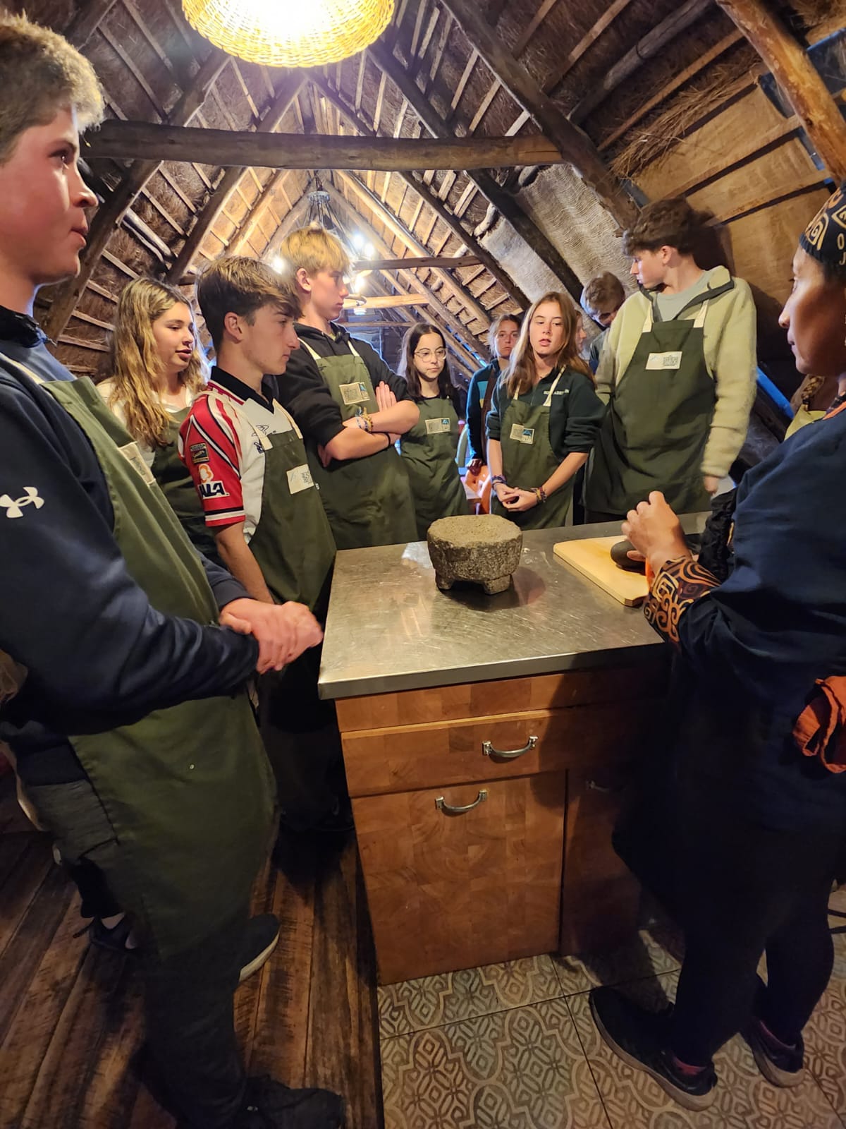 Students stand in circle getting a lesson from local chef