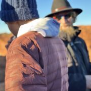 Student stands near local guide wearing wide brimmed hat
