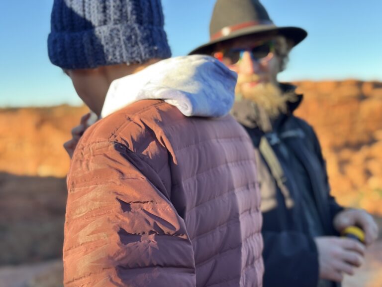 Student stands near local guide wearing wide brimmed hat
