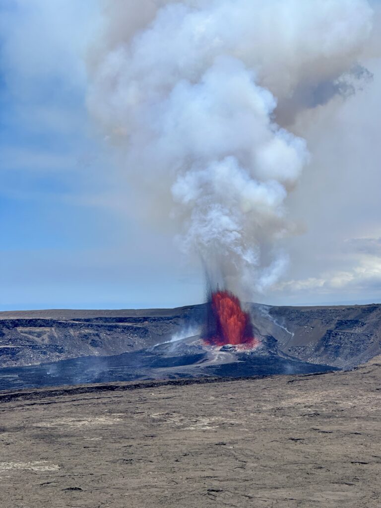 Image of lava bursting up from volcano with smoke billowing up