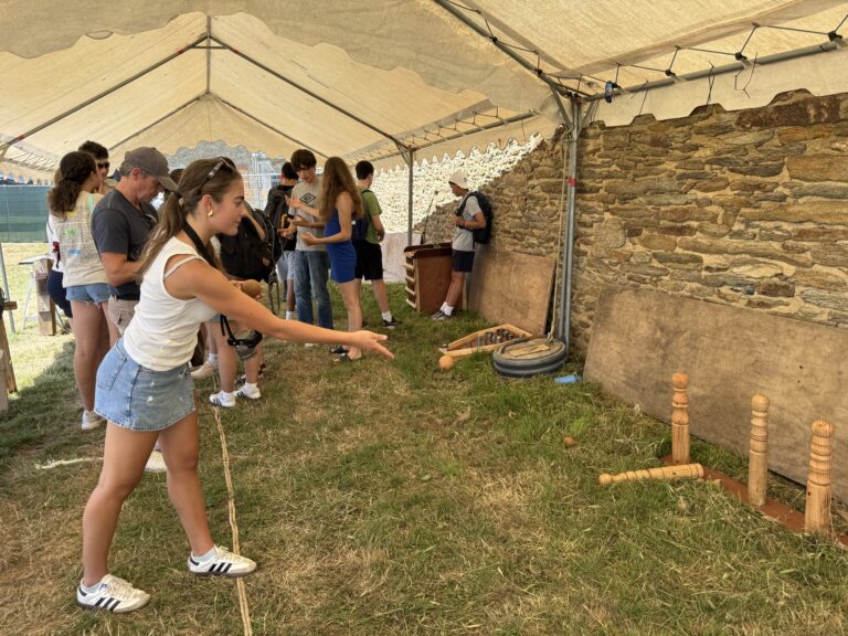 Student throws wooden pin in game at Festival of the West in Le Conquet. 