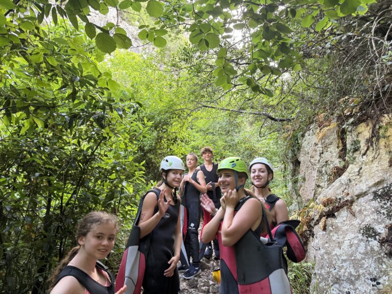 Group of student hike through the forest wearing helmets