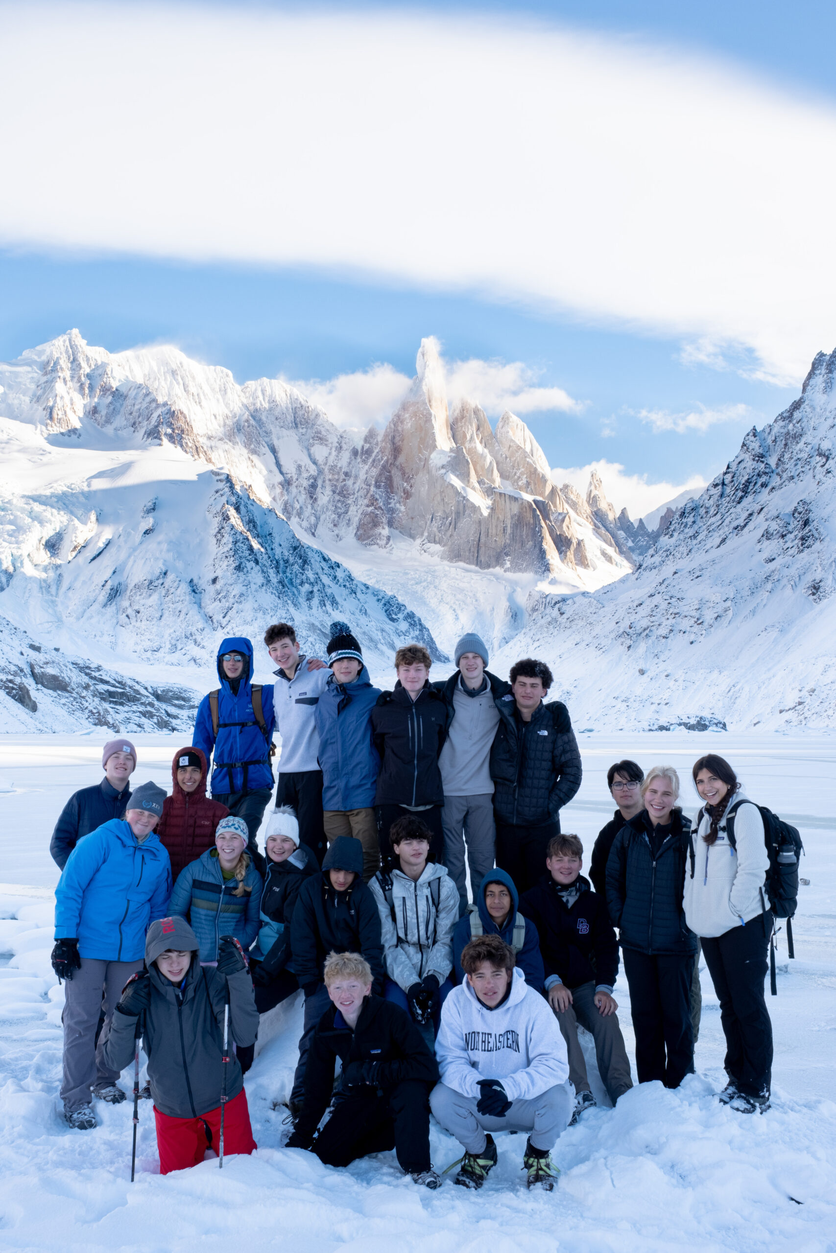 Students and leaders pose for a group photo in front of Patagonian mountain peaks and frozen lake