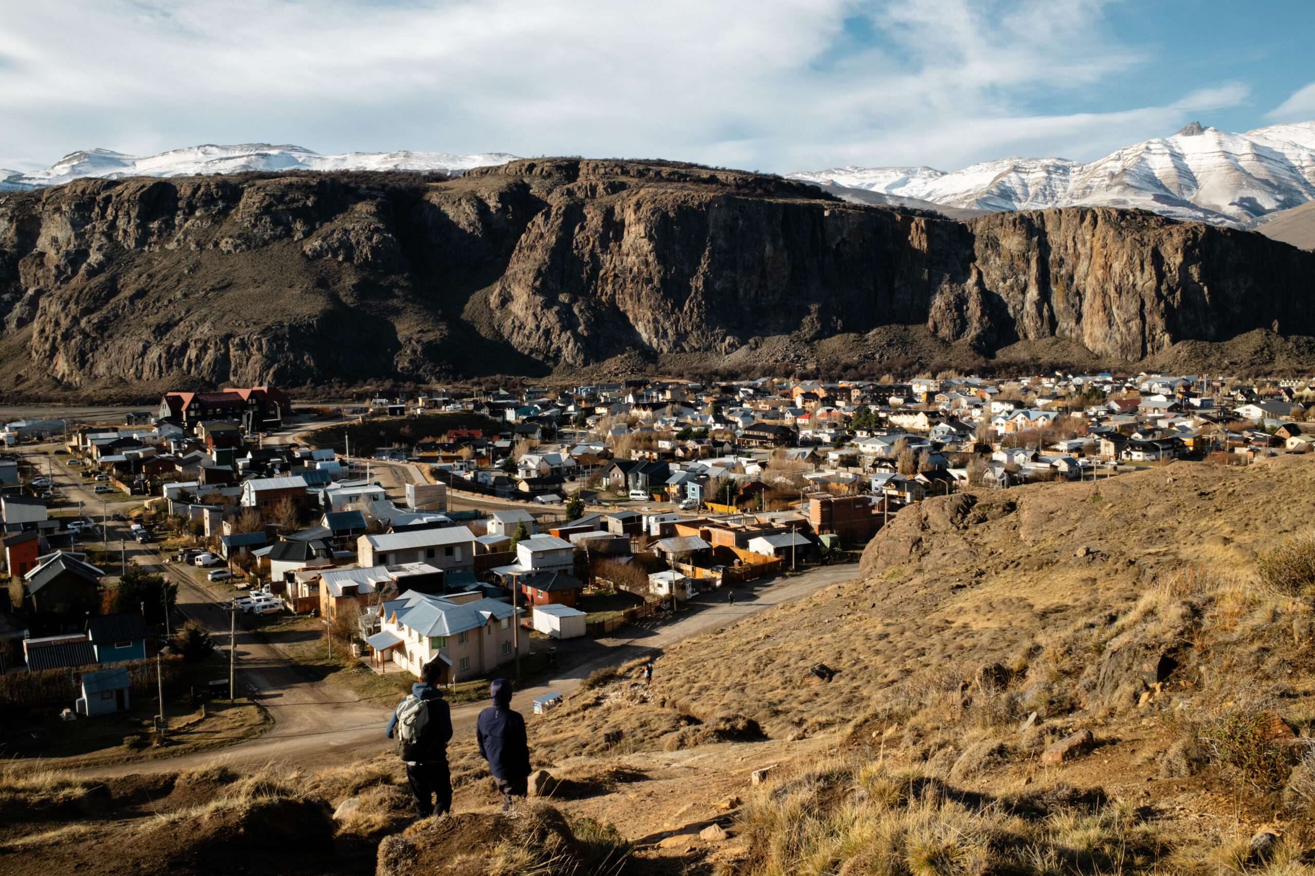Two students look out at view of El Chaltén town from above