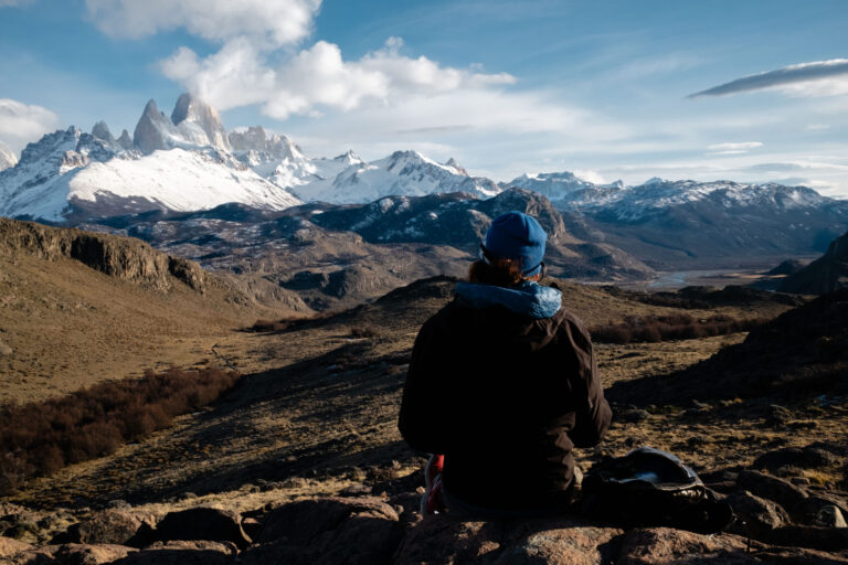 Sitting student looks out at Patagonian mountain landscape