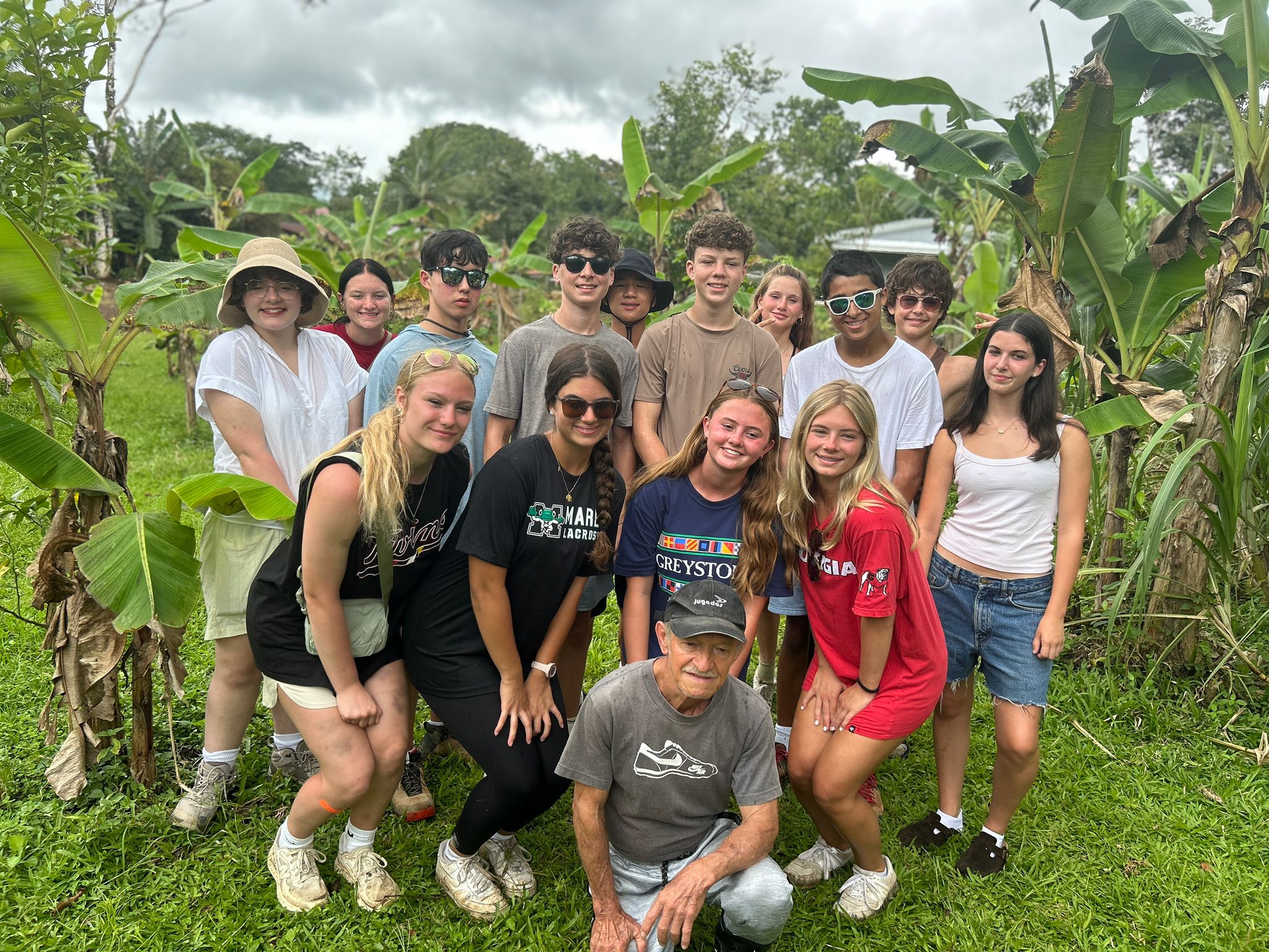 Group photo of students posing outside at sugarcane farm