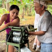 Local instructor lets student crank metal machine to process sugarcane