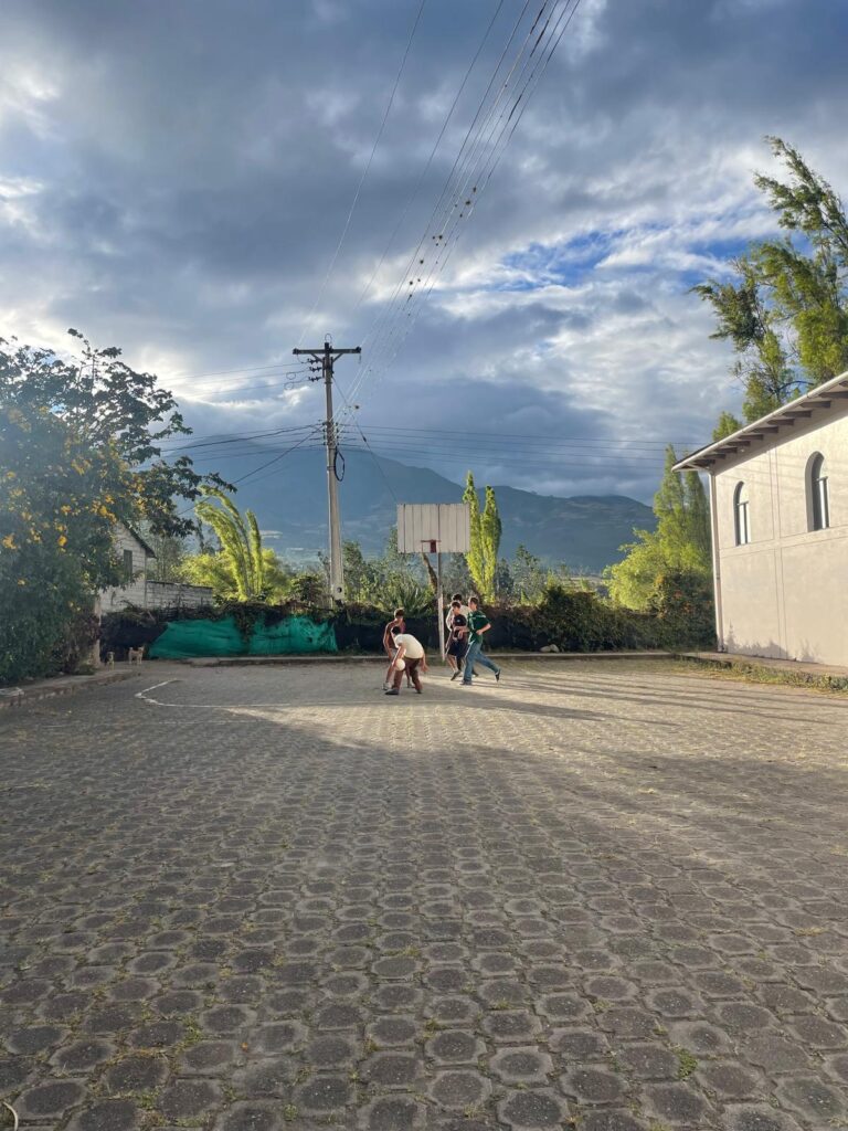 Students play sports in a stone courtyard