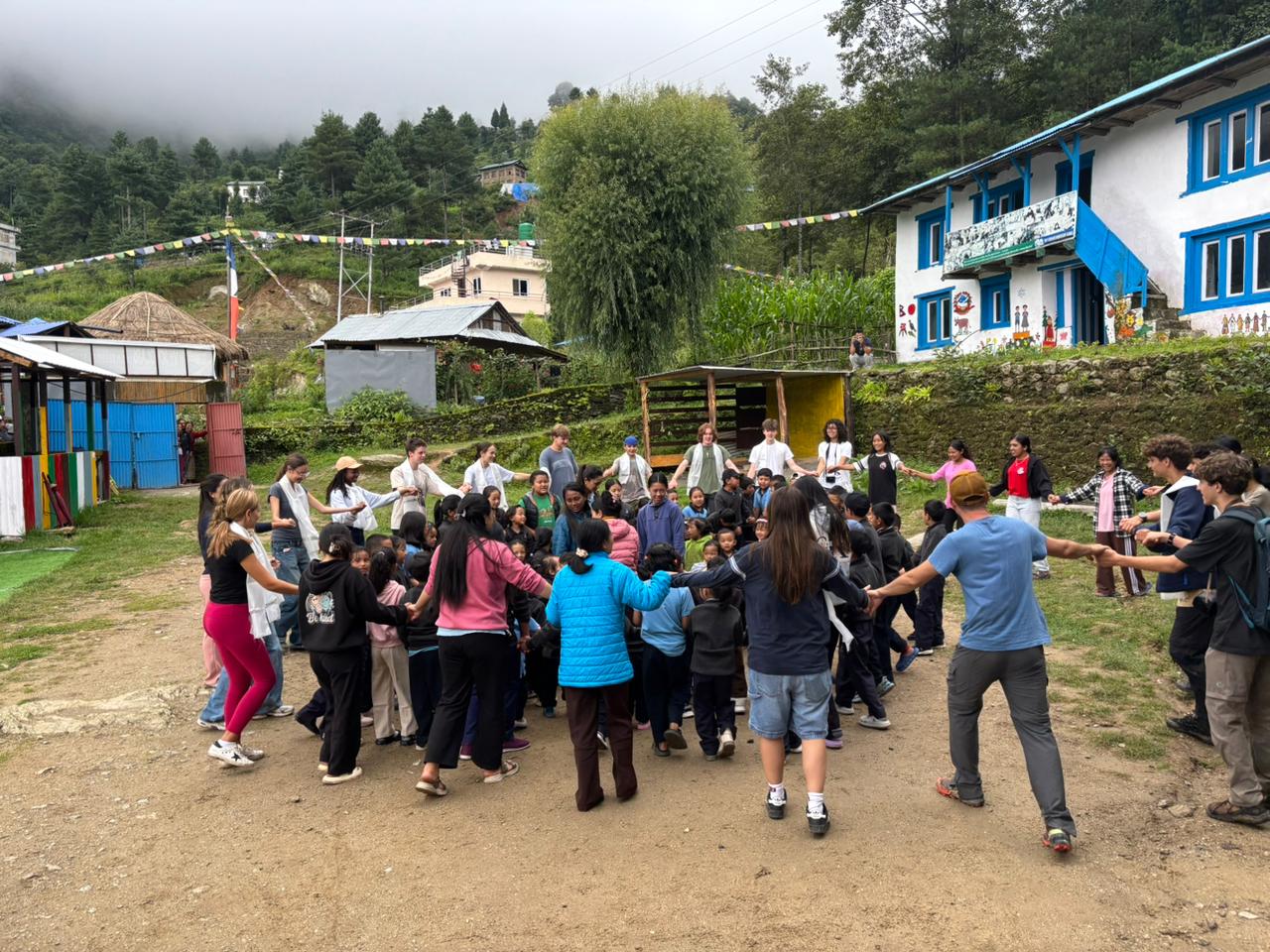 Students and children dance in concentric circles outside
