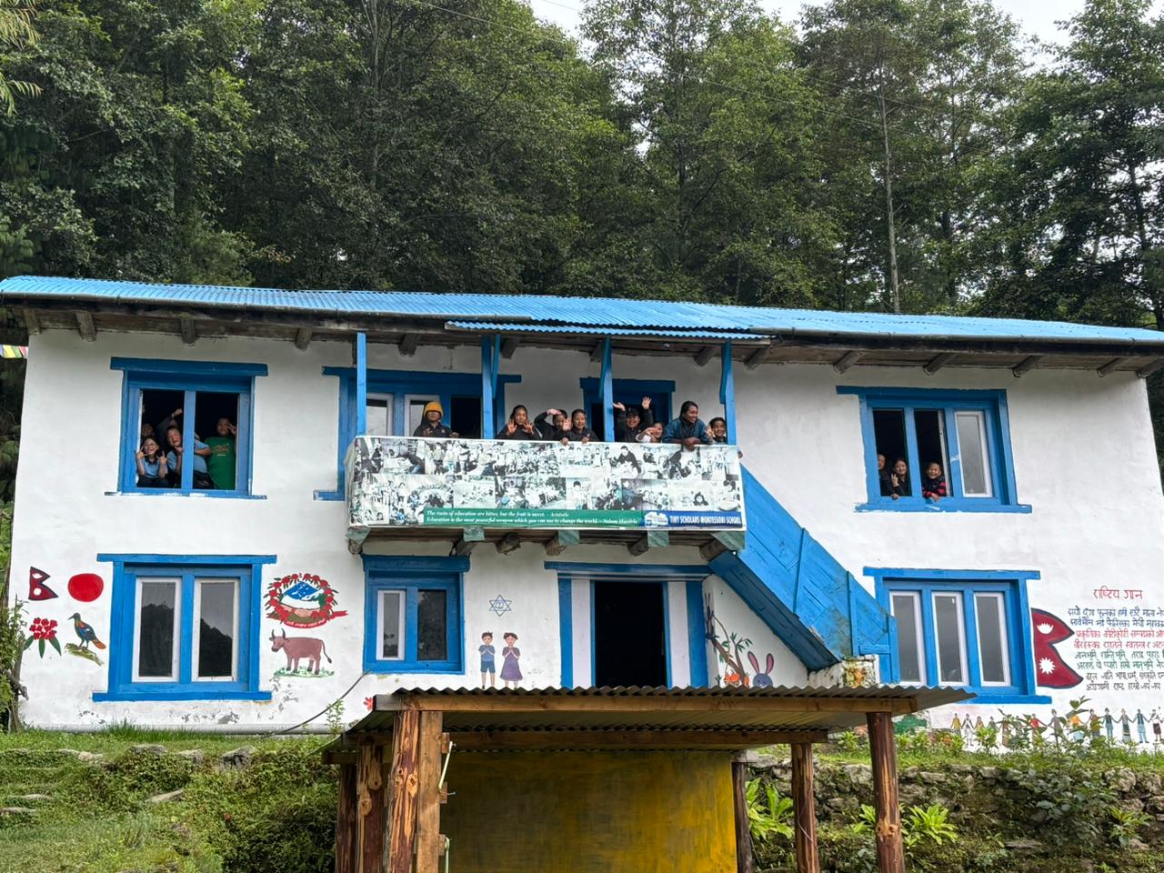 Blue and white school building with kids leaning out the building and waving 