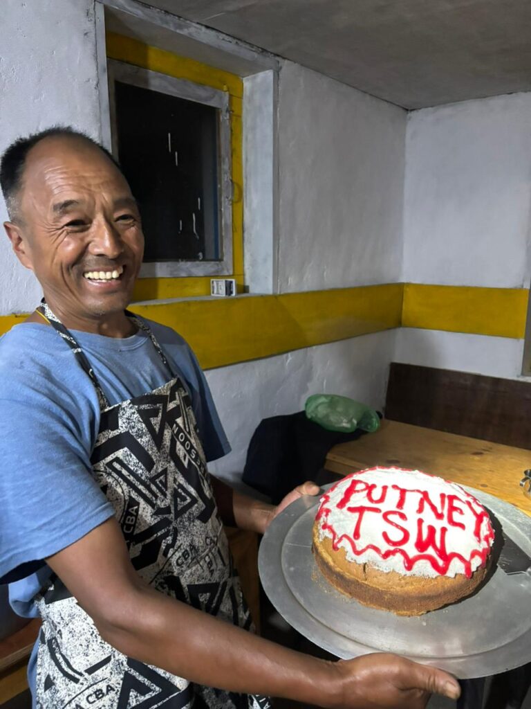Local cook holds up a cake that reads "Putney TSW" in red icing
