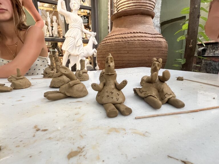 Six handcrafted clay dolls sit on a table