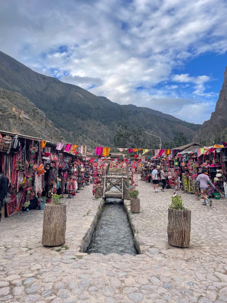 Colorful shops and stores lie between scenic mountain range in Peru