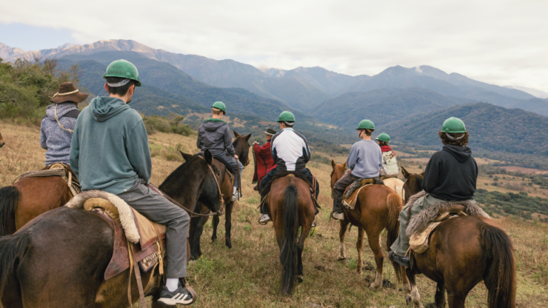 Students riding horses in the mountains in Argentina